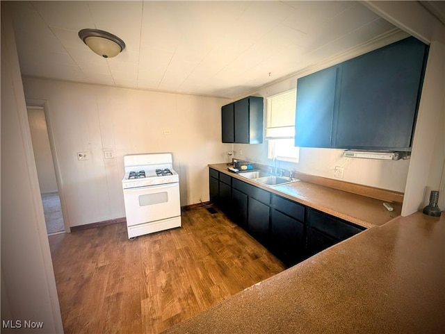 kitchen featuring blue cabinetry, light countertops, white range with gas cooktop, dark wood-style floors, and a sink