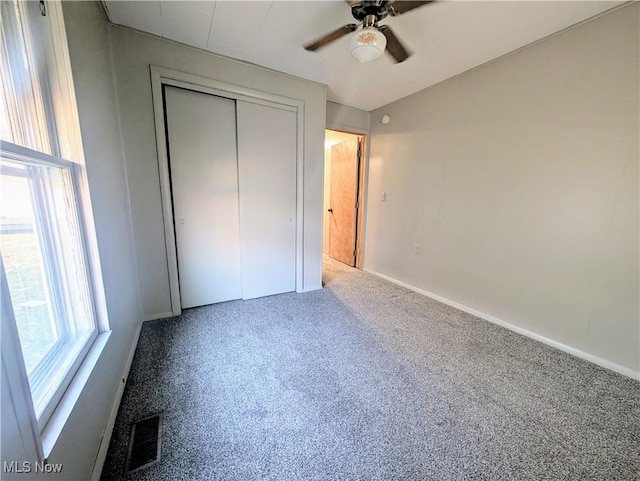 unfurnished bedroom with visible vents, a ceiling fan, a closet, carpet flooring, and baseboards