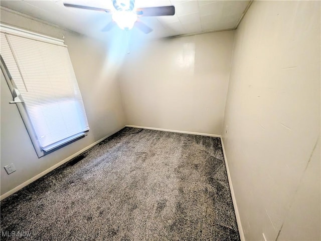 carpeted empty room featuring a ceiling fan and baseboards