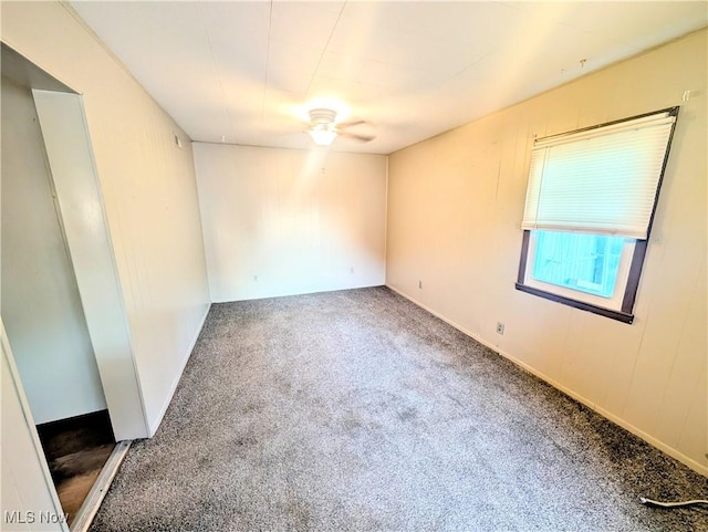 spare room featuring ceiling fan and carpet flooring