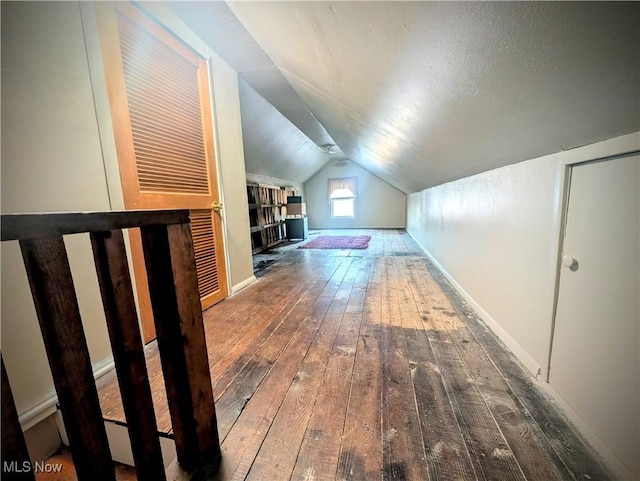 bonus room featuring baseboards, lofted ceiling, and hardwood / wood-style flooring