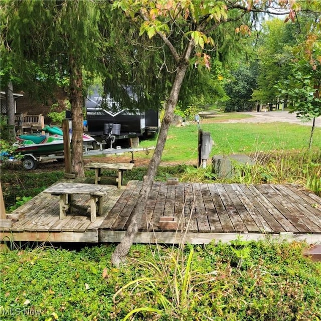 view of property's community featuring a lawn and a deck