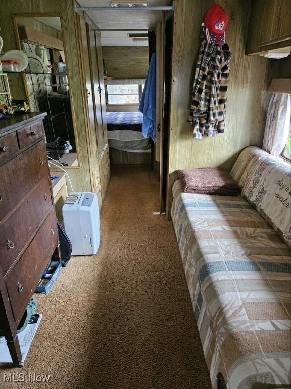 carpeted bedroom with wood walls