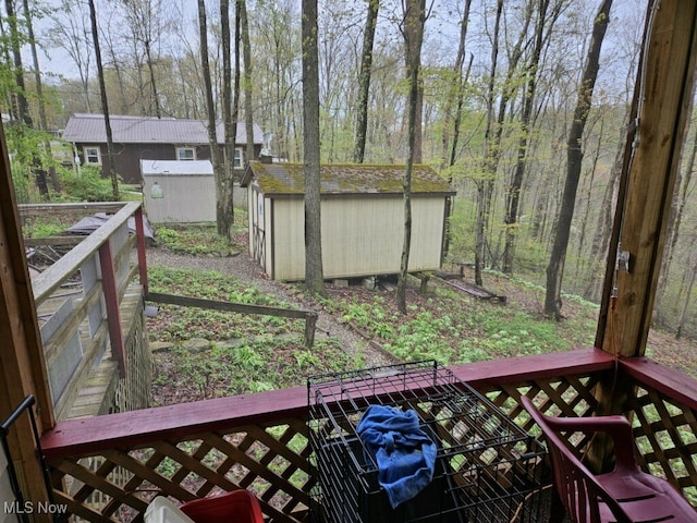 wooden deck featuring a storage unit and an outbuilding