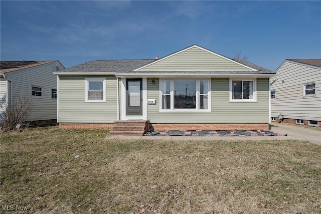 back of house with a lawn and a shingled roof