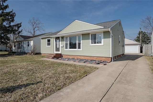 view of front of home featuring a garage, an outdoor structure, a front yard, and entry steps