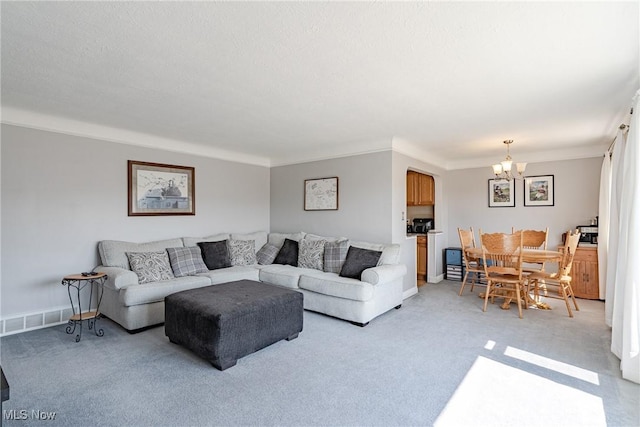 living area with a chandelier, visible vents, light carpet, and baseboards