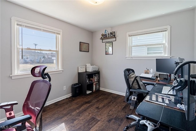 office area with dark wood-type flooring, a healthy amount of sunlight, and baseboards