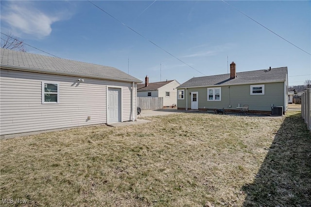 back of property featuring central air condition unit, a lawn, a patio, and fence