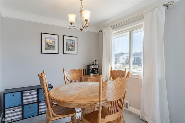 dining space featuring ornamental molding, carpet flooring, baseboards, and a chandelier