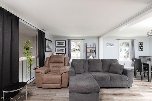 living area with light wood-style floors and crown molding