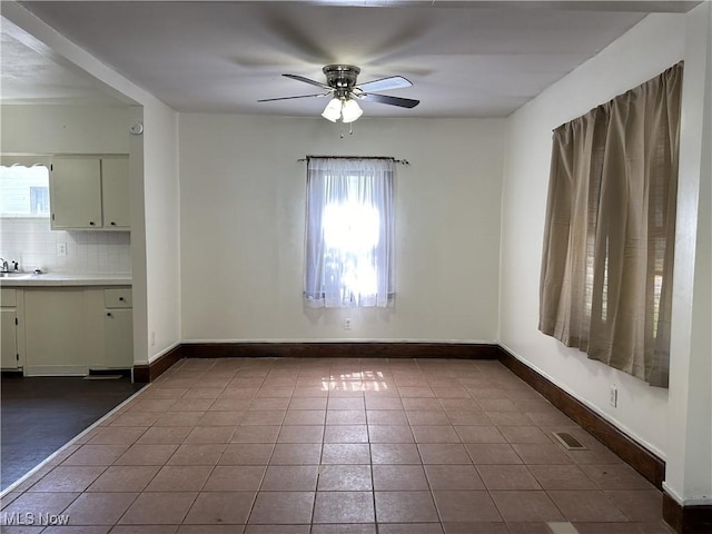 unfurnished dining area with visible vents, baseboards, ceiling fan, and tile patterned flooring