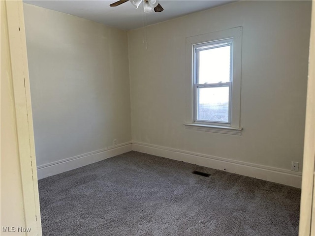 spare room with carpet flooring, ceiling fan, baseboards, and visible vents