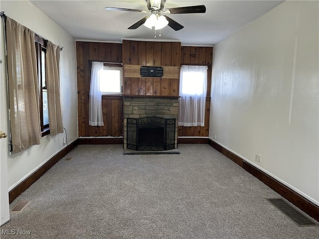 unfurnished living room with carpet, a fireplace, visible vents, and baseboards