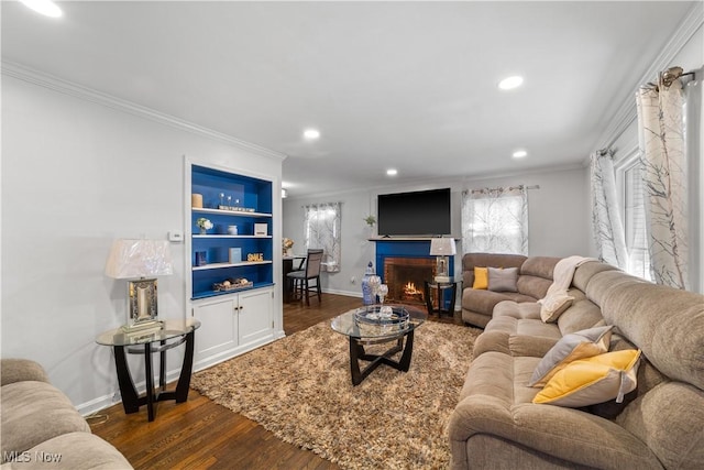 living room featuring baseboards, built in shelves, dark wood-style flooring, and crown molding