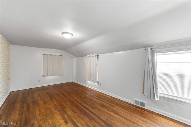 bonus room with hardwood / wood-style flooring, baseboards, visible vents, and lofted ceiling