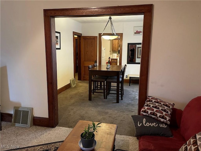 carpeted dining area featuring visible vents and baseboards