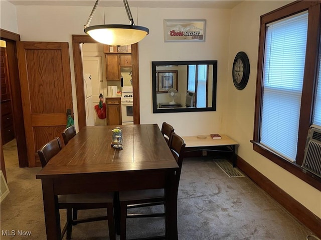 dining room with baseboards and light colored carpet