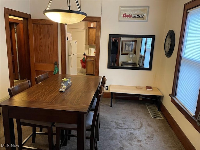 carpeted dining area with visible vents and baseboards