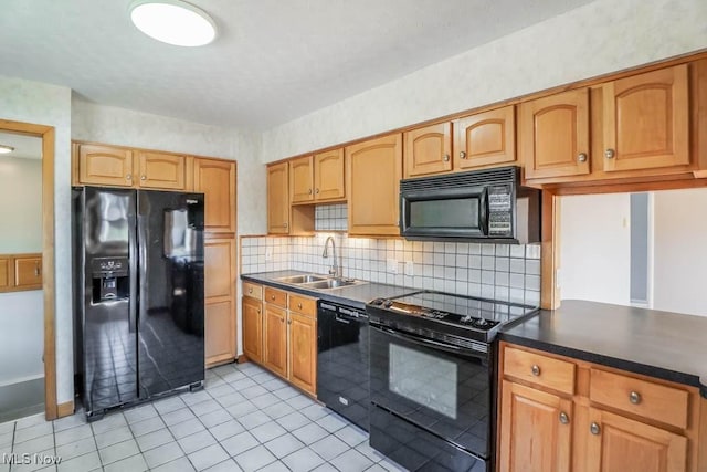 kitchen with black appliances, a sink, dark countertops, tasteful backsplash, and light tile patterned floors