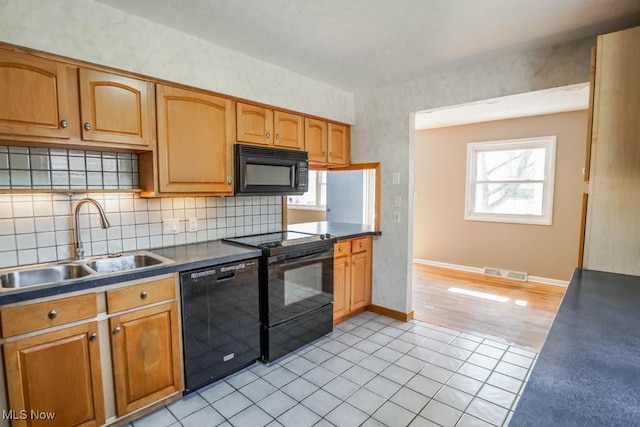 kitchen with visible vents, light tile patterned flooring, a sink, black appliances, and backsplash