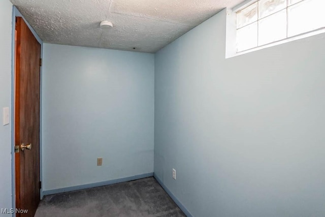 carpeted spare room with baseboards and a textured ceiling