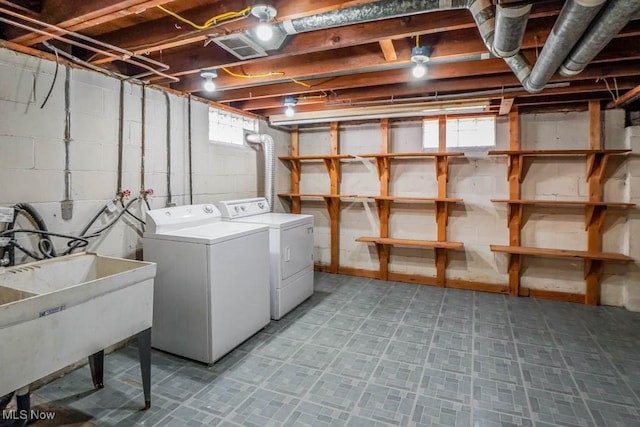 washroom with a sink, separate washer and dryer, light floors, and laundry area