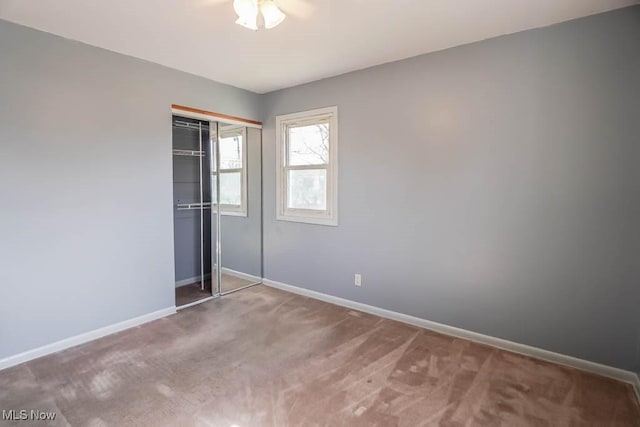 unfurnished bedroom featuring a closet, baseboards, and carpet