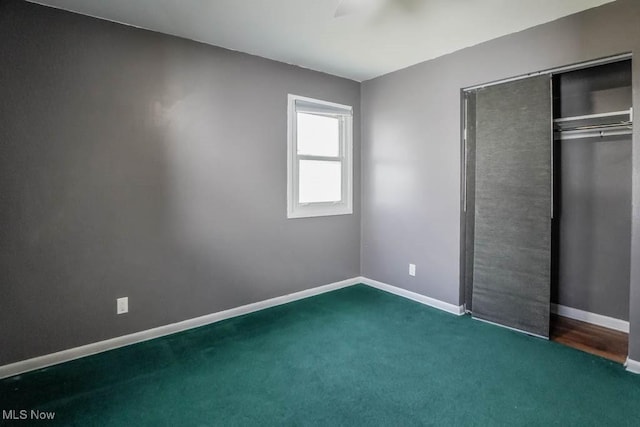 unfurnished bedroom featuring carpet, baseboards, a closet, and ceiling fan