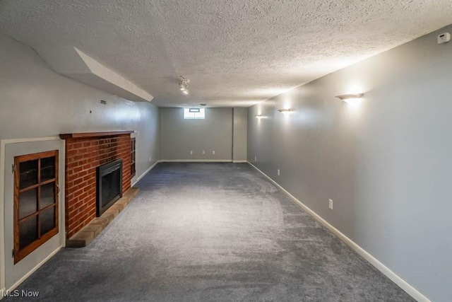 basement with a textured ceiling, a brick fireplace, baseboards, and carpet