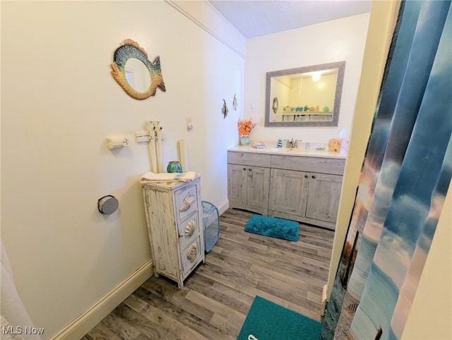 bathroom featuring vanity, baseboards, and wood finished floors