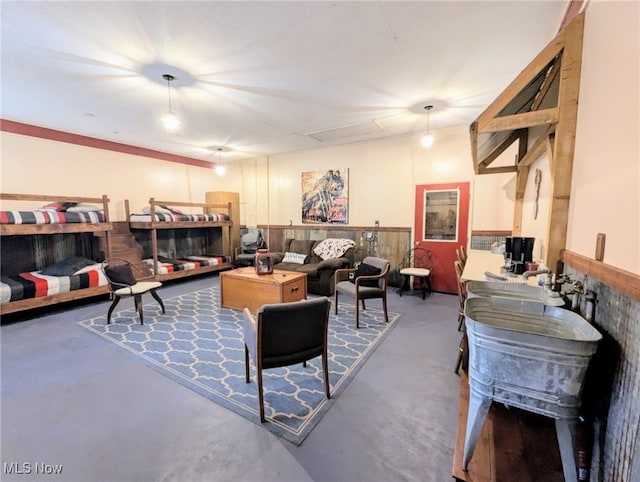 living room with attic access and finished concrete flooring