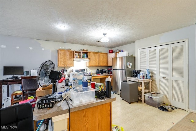 kitchen featuring light floors, open shelves, stainless steel appliances, light countertops, and a textured ceiling