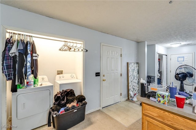 laundry room with a textured ceiling, laundry area, baseboards, and washer and clothes dryer