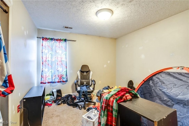 bedroom featuring visible vents, a textured ceiling, and carpet flooring