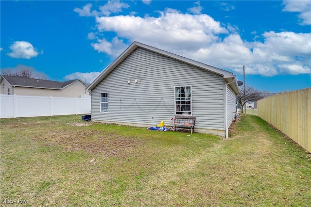 rear view of property featuring a yard and fence