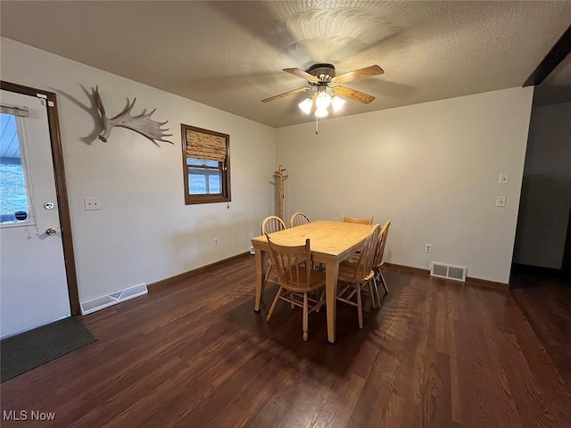 dining space with wood finished floors, visible vents, and a textured ceiling