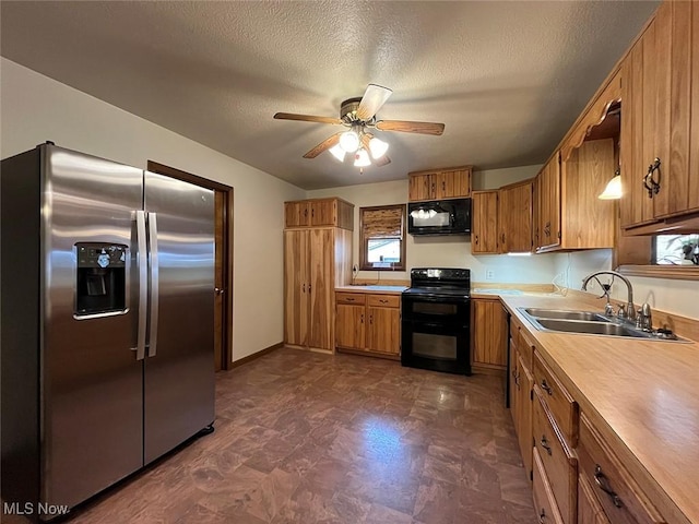 kitchen with ceiling fan, a sink, black appliances, light countertops, and brown cabinets