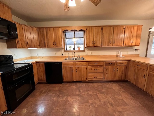 kitchen featuring brown cabinets, black appliances, light countertops, and a sink