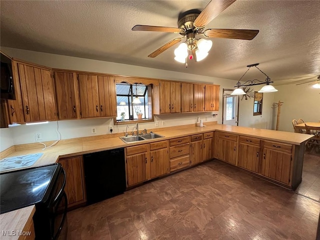 kitchen featuring light countertops, brown cabinets, a peninsula, black appliances, and a sink