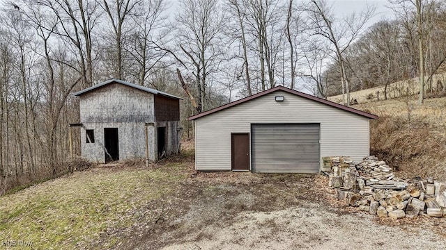 view of outdoor structure featuring an outbuilding and dirt driveway