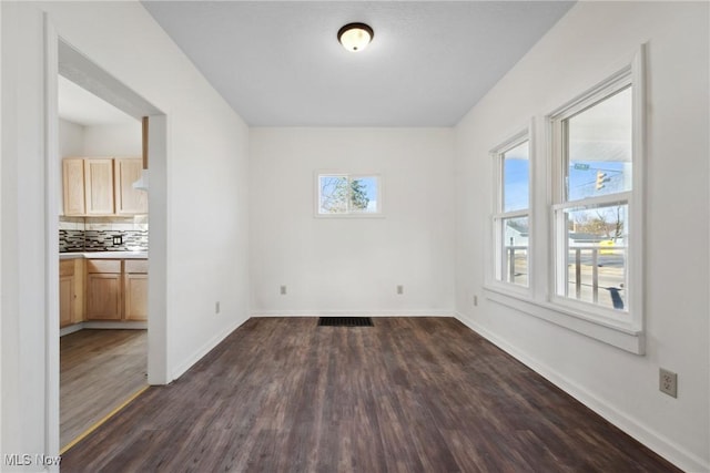 spare room with visible vents, dark wood-style floors, and baseboards