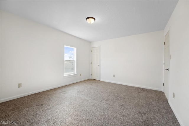 carpeted empty room with baseboards