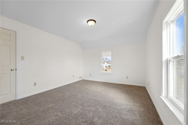 empty room with baseboards, carpet floors, and vaulted ceiling