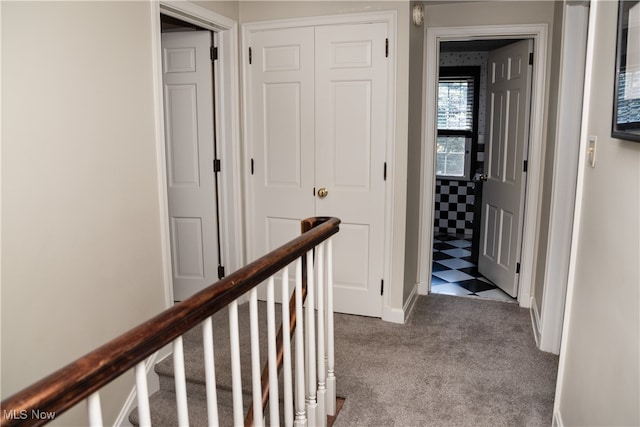 corridor with carpet flooring, an upstairs landing, and baseboards