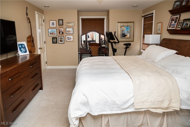 bedroom with baseboards and light carpet