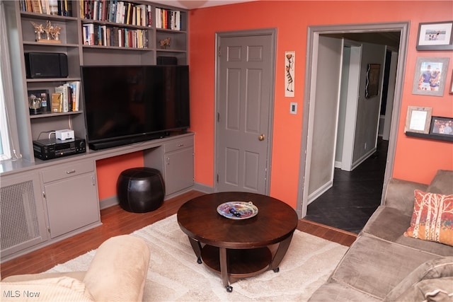 living area featuring wood finished floors and built in desk