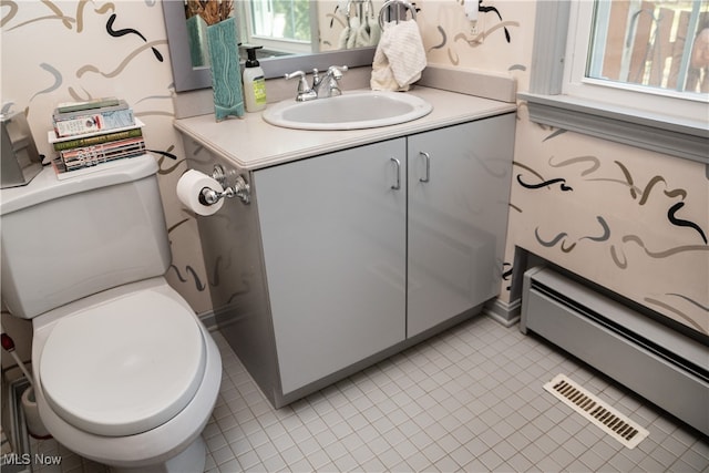 half bathroom with baseboard heating, toilet, vanity, and visible vents