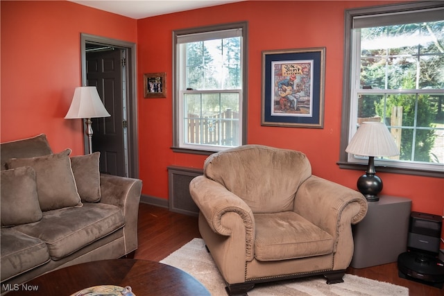 living area featuring wood finished floors, visible vents, and baseboards