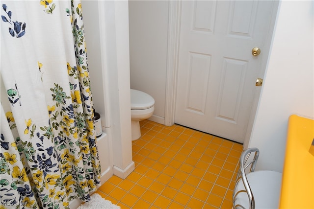 bathroom featuring toilet, a shower with shower curtain, and baseboards